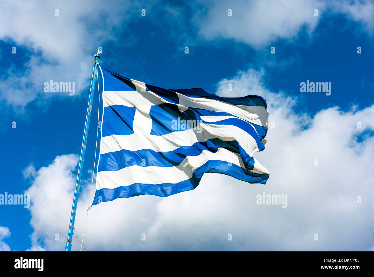 Gran ondea la bandera griega contra el cielo azul con nubes blancas Foto de stock