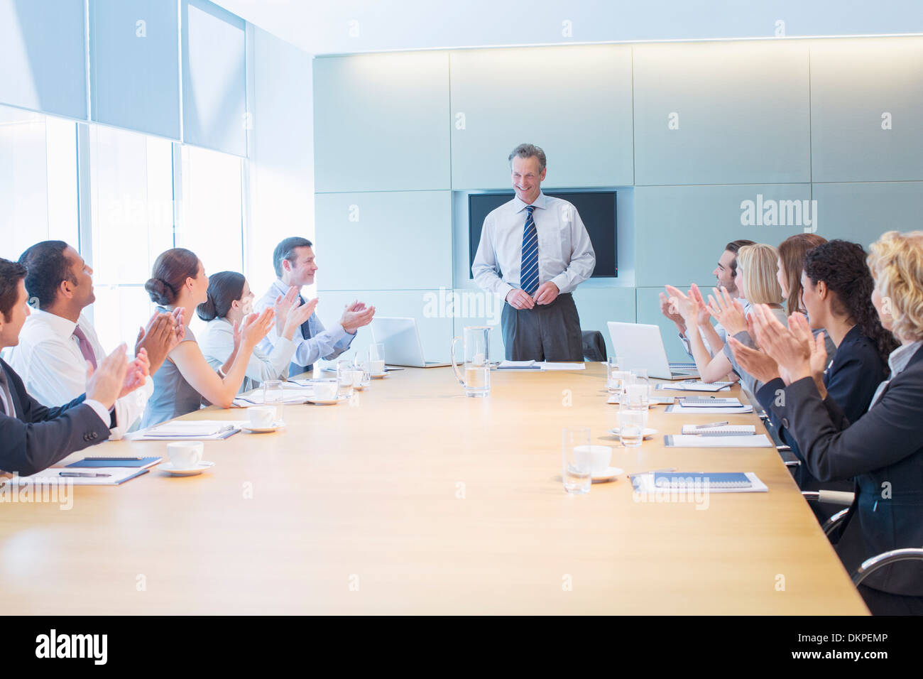 Gente de negocios aplaudiendo colega en reunión Foto de stock