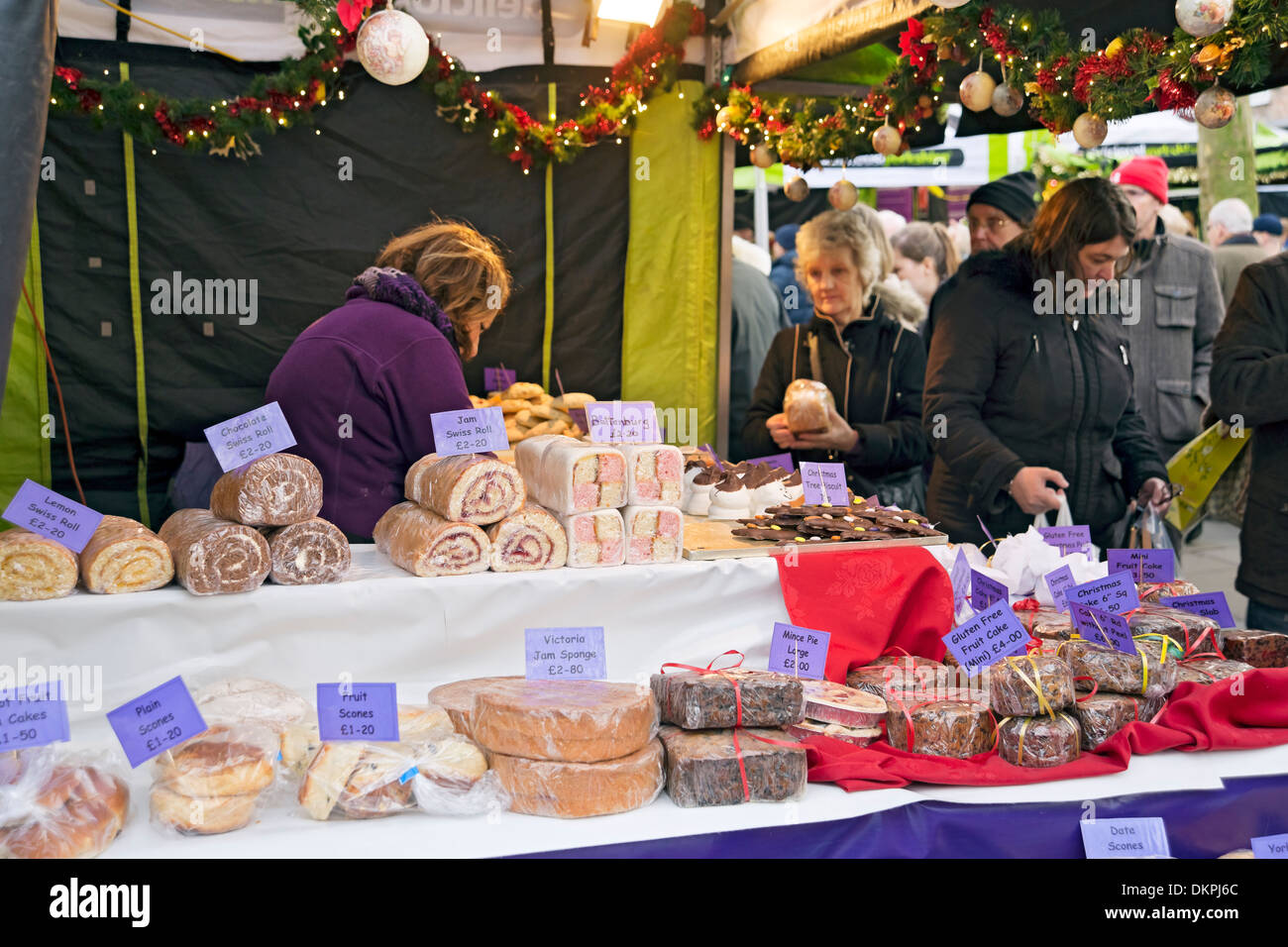 Gente turistas visitantes en el puesto de venta de pasteles en la Navidad St Nicholas Fayre York North Yorkshire Inglaterra Reino Unido GB Gran Bretaña Foto de stock