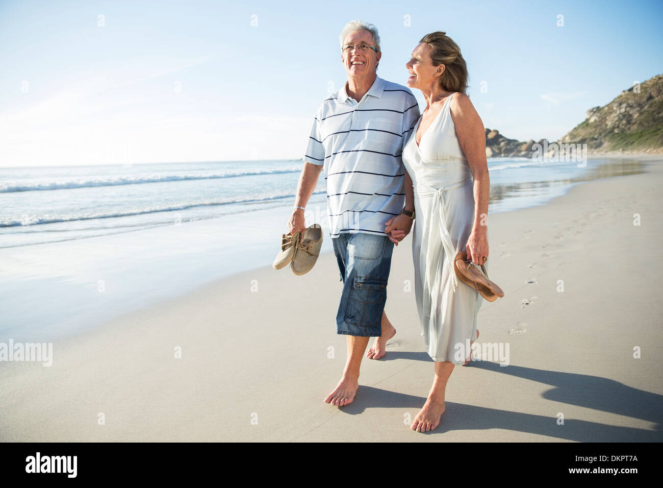 Las parejas ancianas caminando en la playa Foto de stock