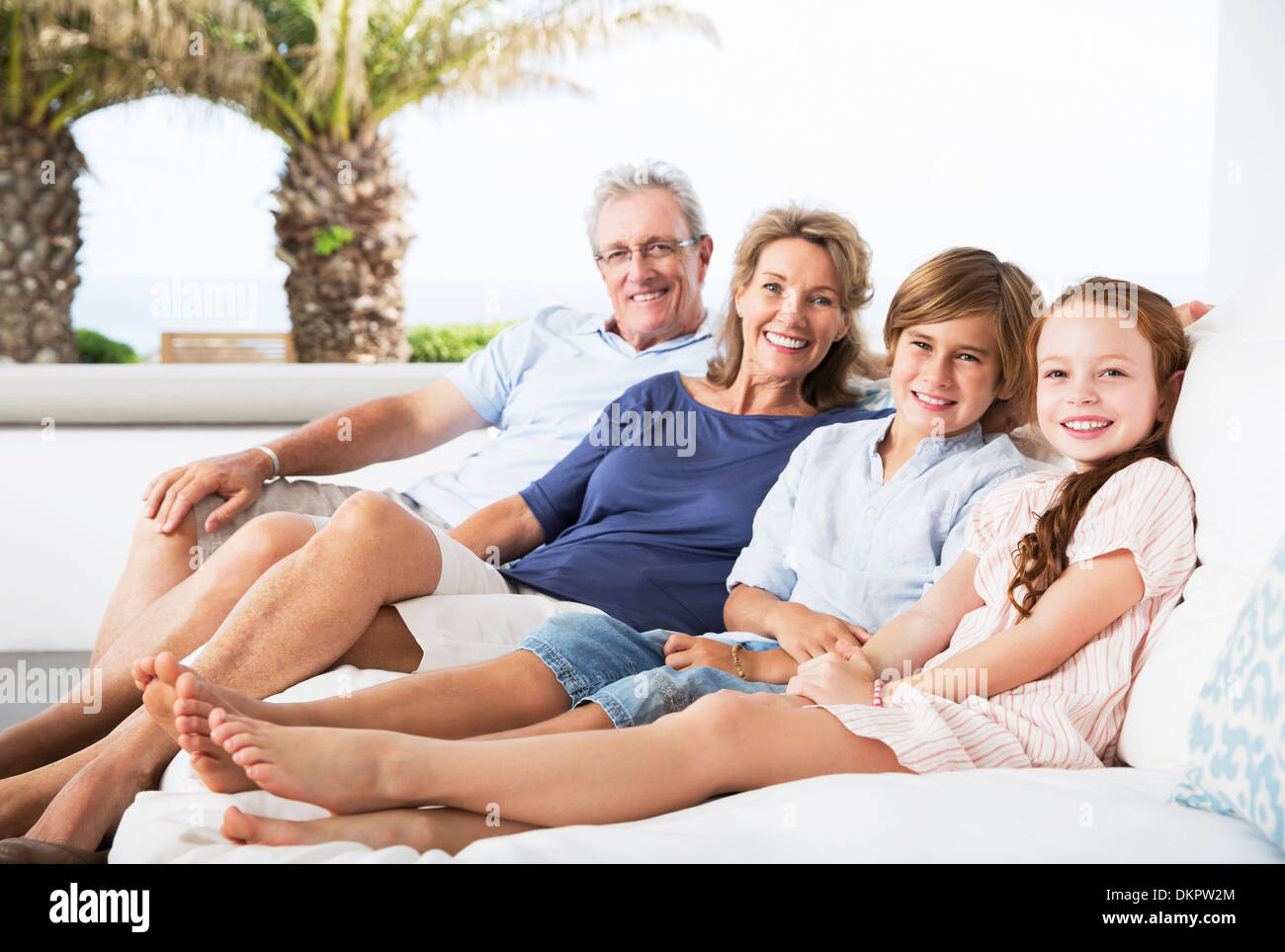 Pareja de ancianos y nietos relajándose en el sofá Foto de stock