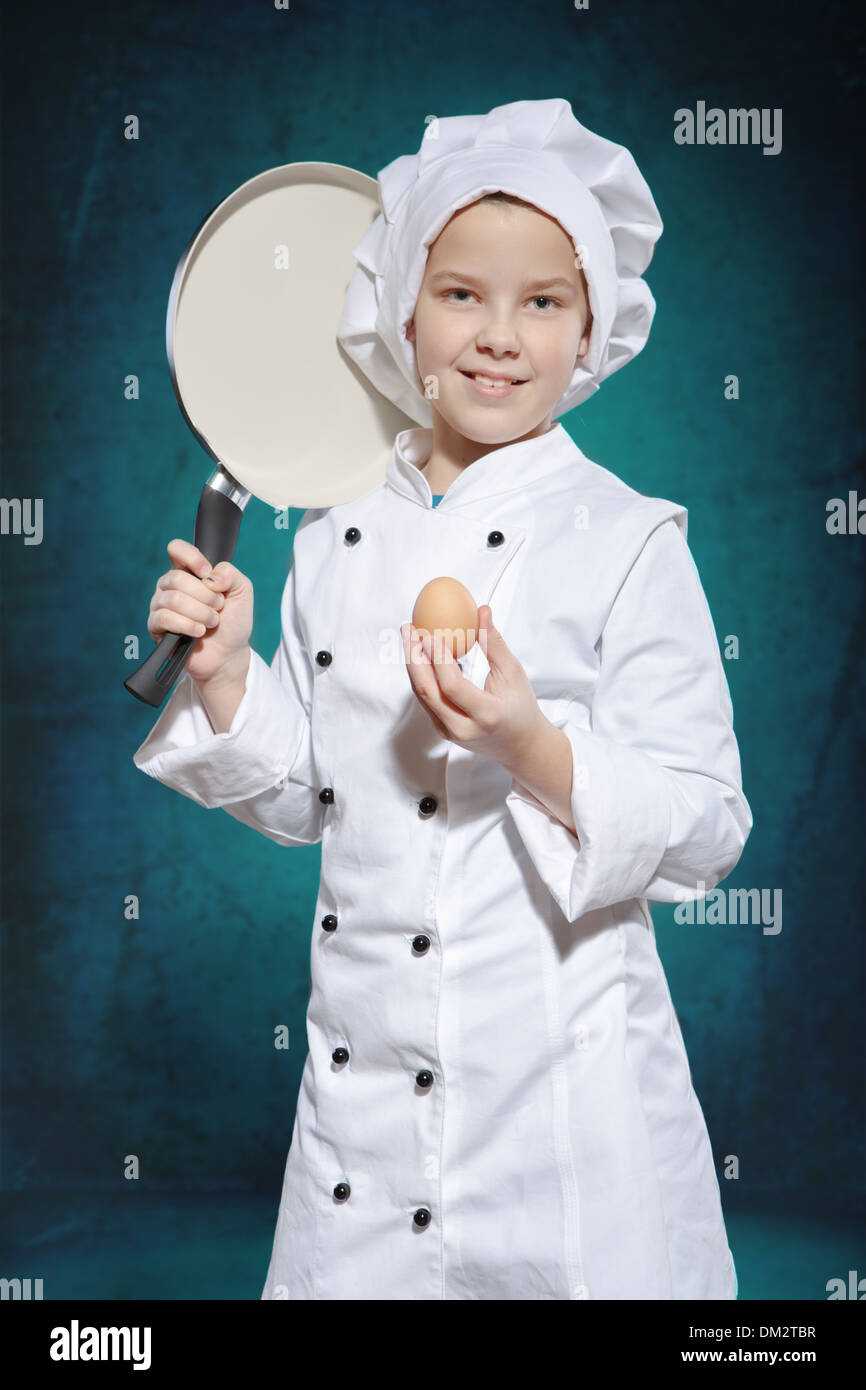 Las hembras jóvenes de cocinar con una sartén y un huevo Foto de stock
