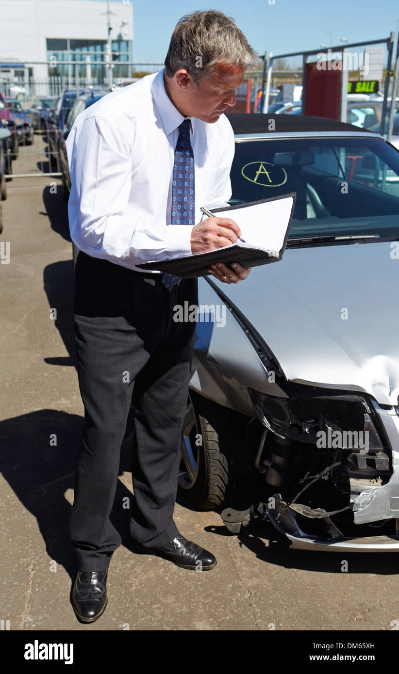 Ajustador de pérdida de inspeccionar el automóvil involucrado en un accidente Foto de stock