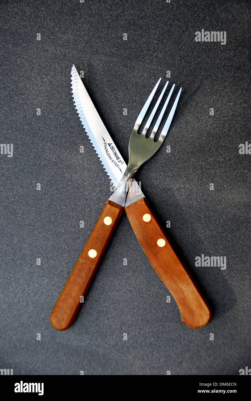 Cuchillo y tenedor cruz. sobre un fondo gris pizarra cubierta menú Foto de stock