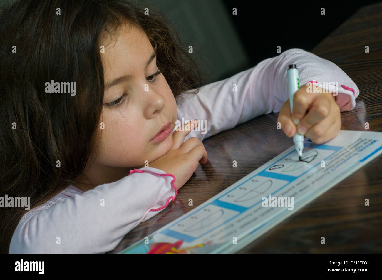 Niña de seis años haciendo ejercicios de matemáticas. Foto de stock