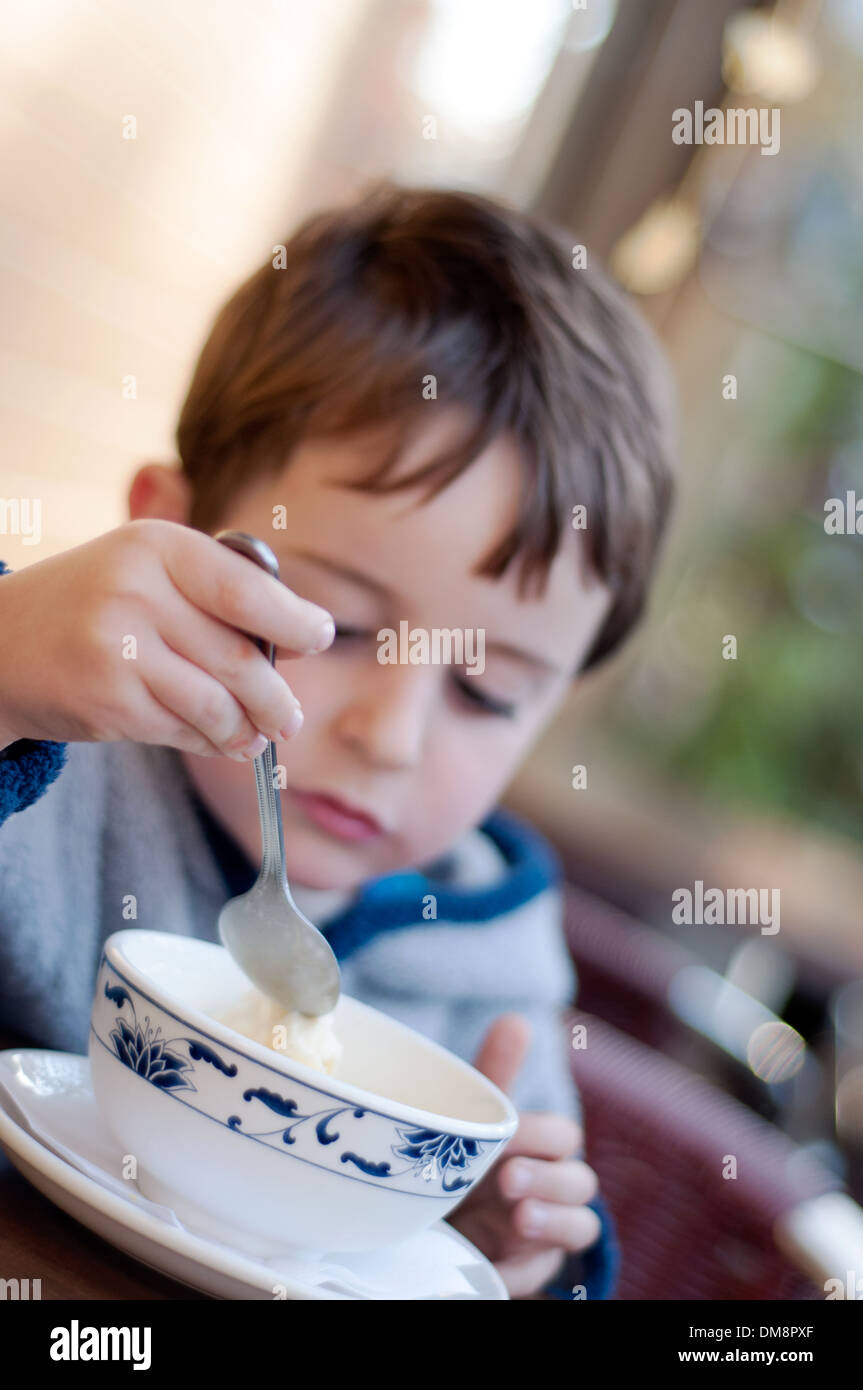 Cuatro años boy comer helado Foto de stock