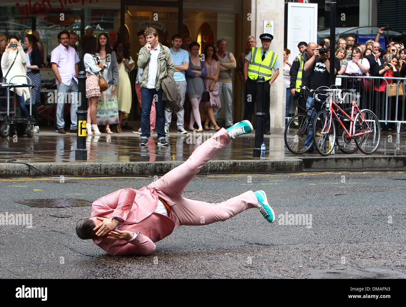 Robbie Williams realiza una rutina de breakdance en traje rosa y turquesa Nike de alta-top zapatos como filma las escenas de su nueva Fotografía de stock - Alamy
