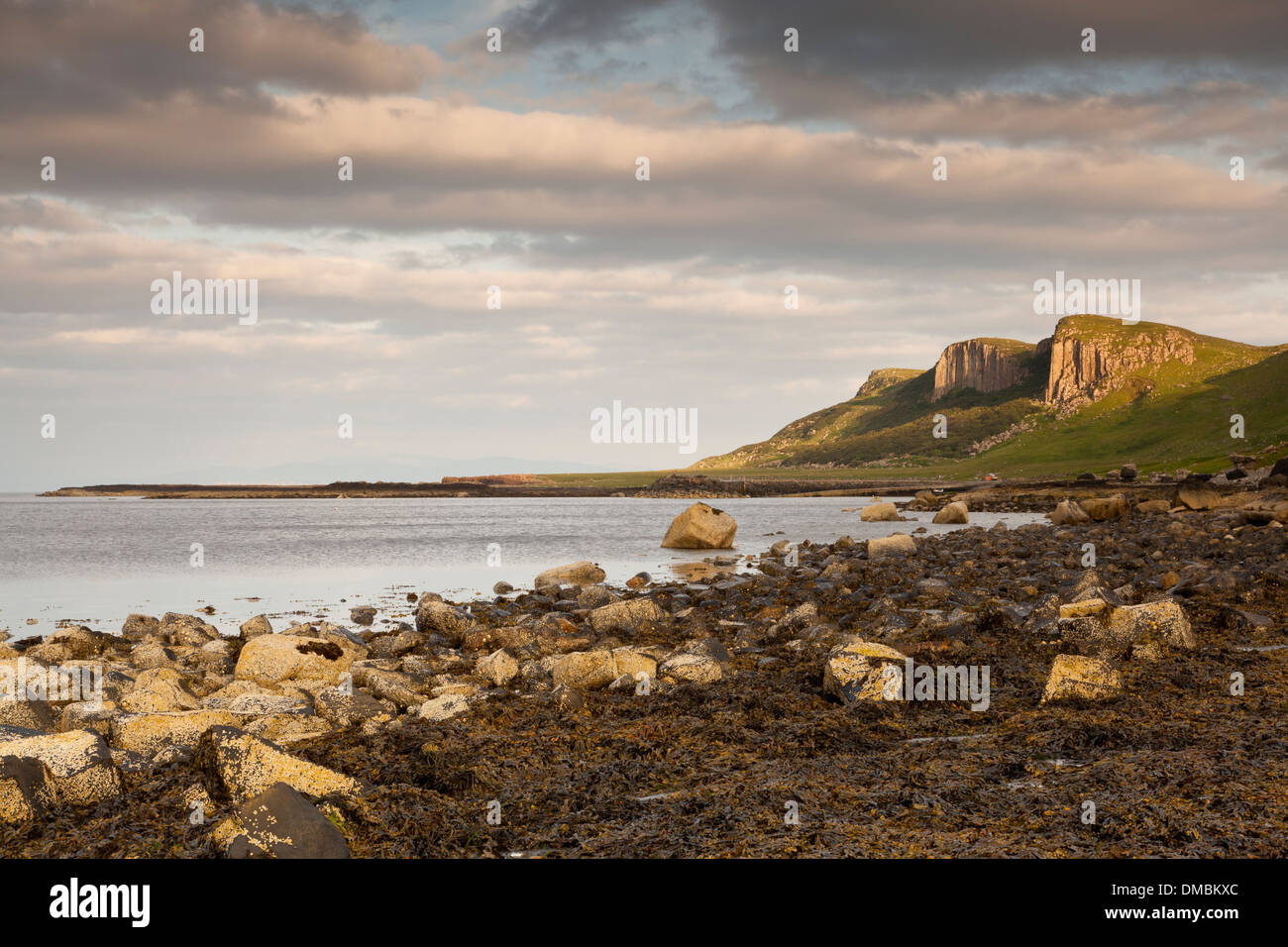 Puesta de sol sobre un acantilado con vistas a la playa de la Bahía de contrafuertes Staffin, Staffin, Isla de Skye, Escocia, Reino Unido Foto de stock