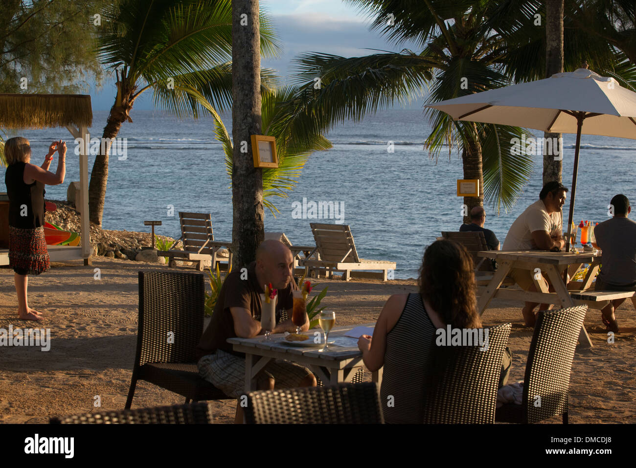 La Isla de Rarotonga. Islas Cook. La Polinesia. Océano Pacífico Sur. Los turistas fotografiar el mar y disfrutando de la puesta de sol Foto de stock