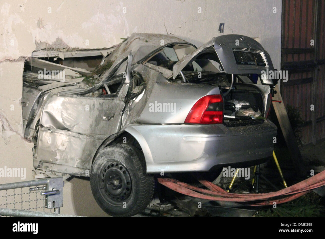 Ochsenhausen-Reinstetten, Alemania. 13 dic, 2013. Un coche está pegado en la pared de una casa en Ochsenhausen-Reinstetten, Alemania, el 13 de diciembre de 2013. El coche se estrelló en un salón de 15 m después de volar por el aire. La policía dijo que el conductor murió en el accidente y la pareja viven en th ehouse resultaron gravemente heridos. Foto: Thomas Poeppel/dpa/Alamy Live News Foto de stock