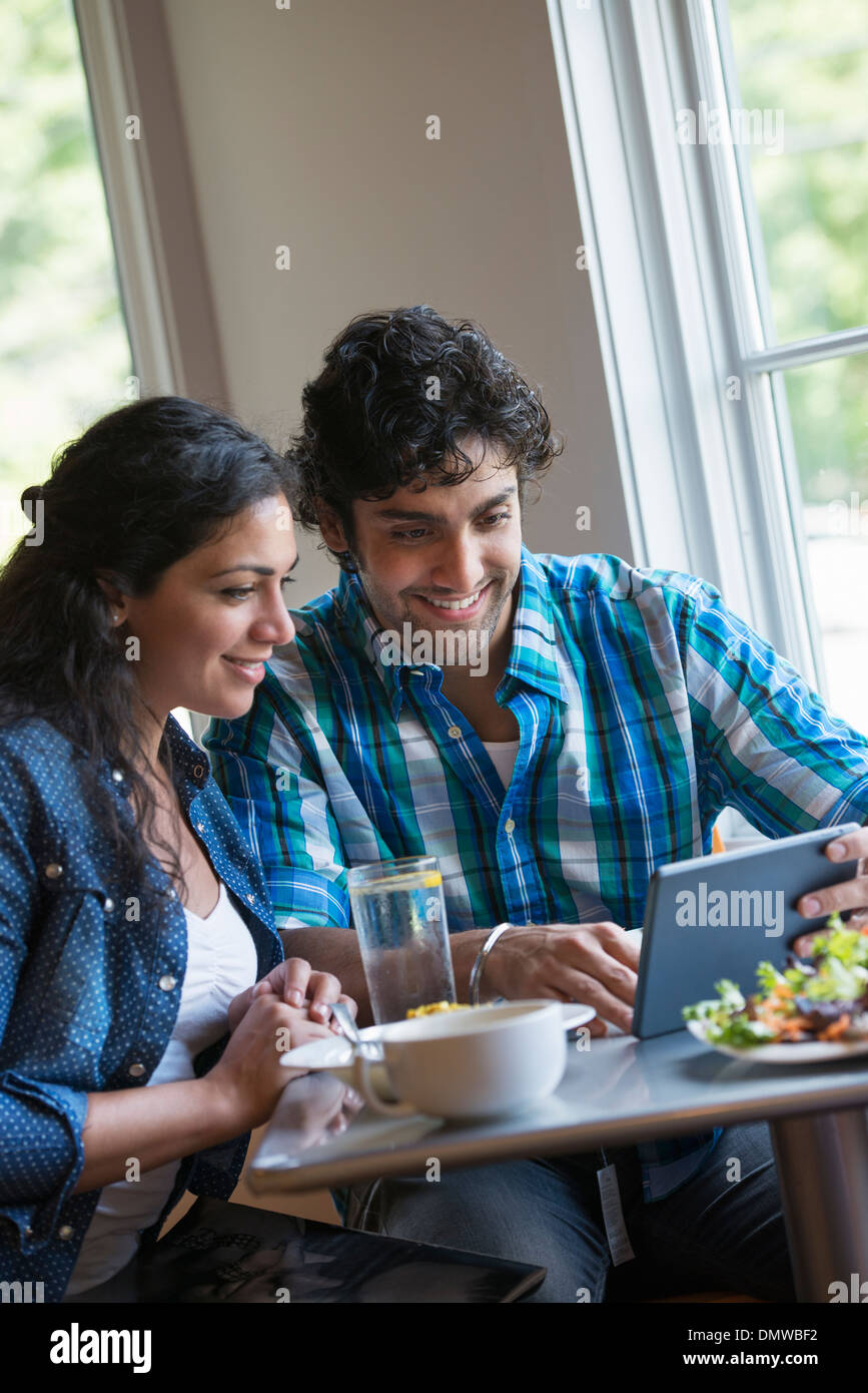 Una pareja sentada mirando una tableta digital. Foto de stock