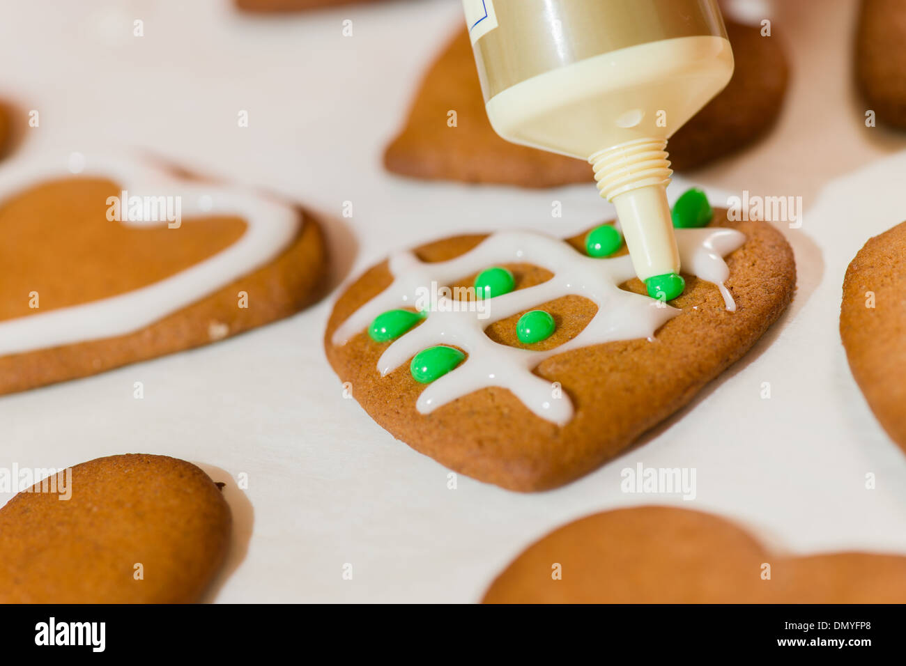 Decorar galletas de jengibre con azúcar, pergamino debajo Foto de stock