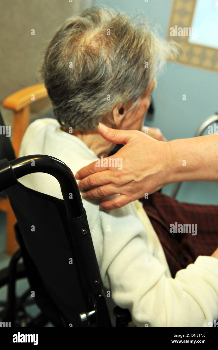 Anciana en un hogar de asistencia ha ayudado fuera de su silla de ruedas. Foto de stock