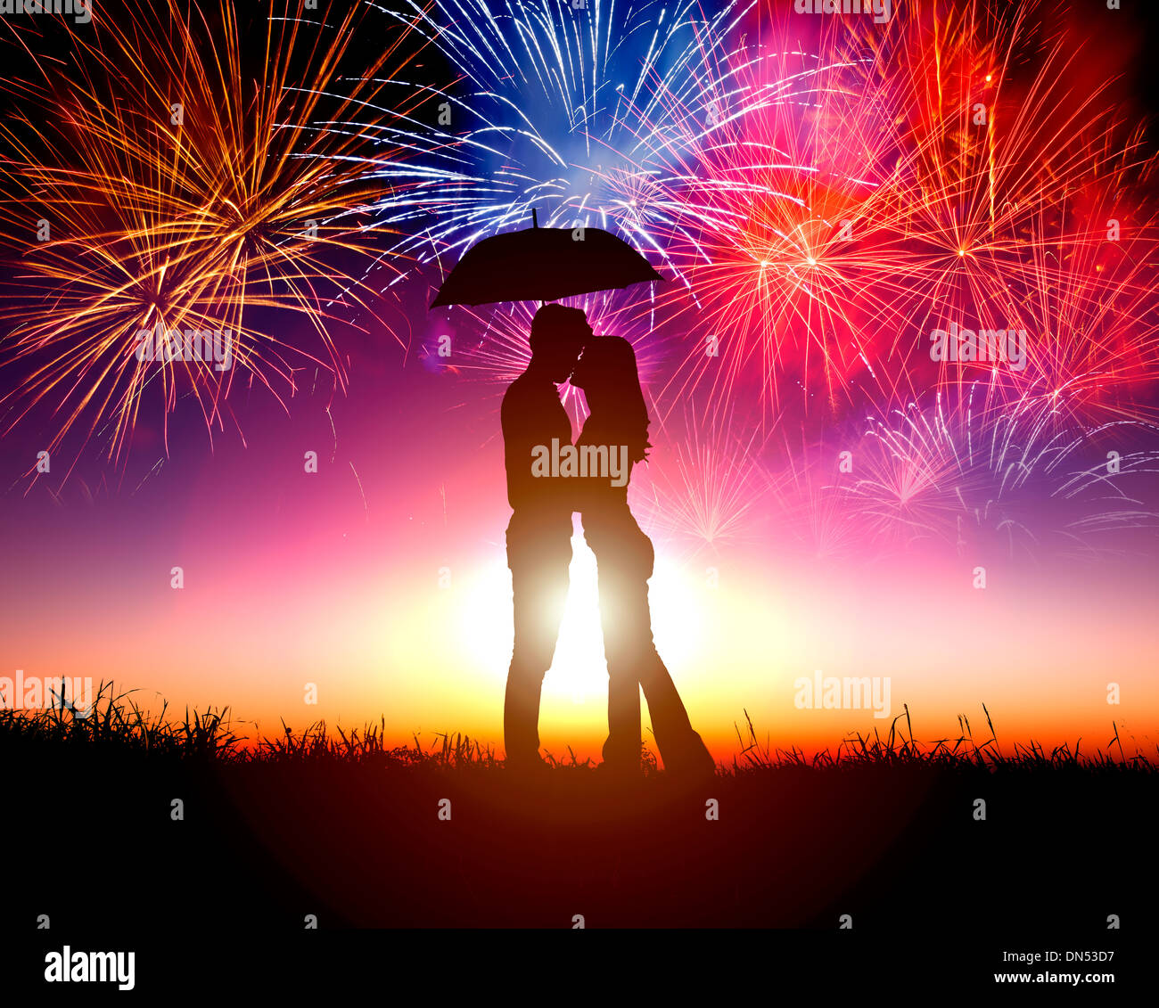 Pareja besándose bajo el paraguas con fuegos artificiales en el cielo Foto de stock