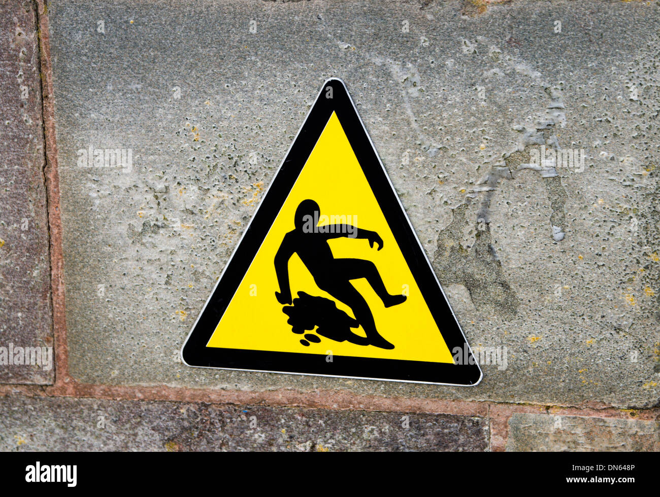 Señal de advertencia de superficie resbaladiza, la Bahía de Cardiff, Gales. Foto de stock