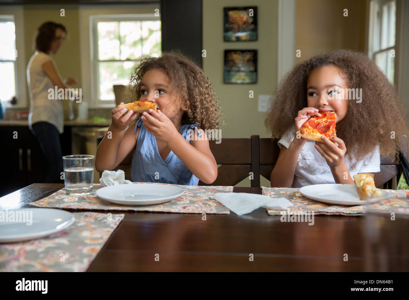 Las niñas de raza mixta comer pizza en la mesa Fotografía de stock - Alamy