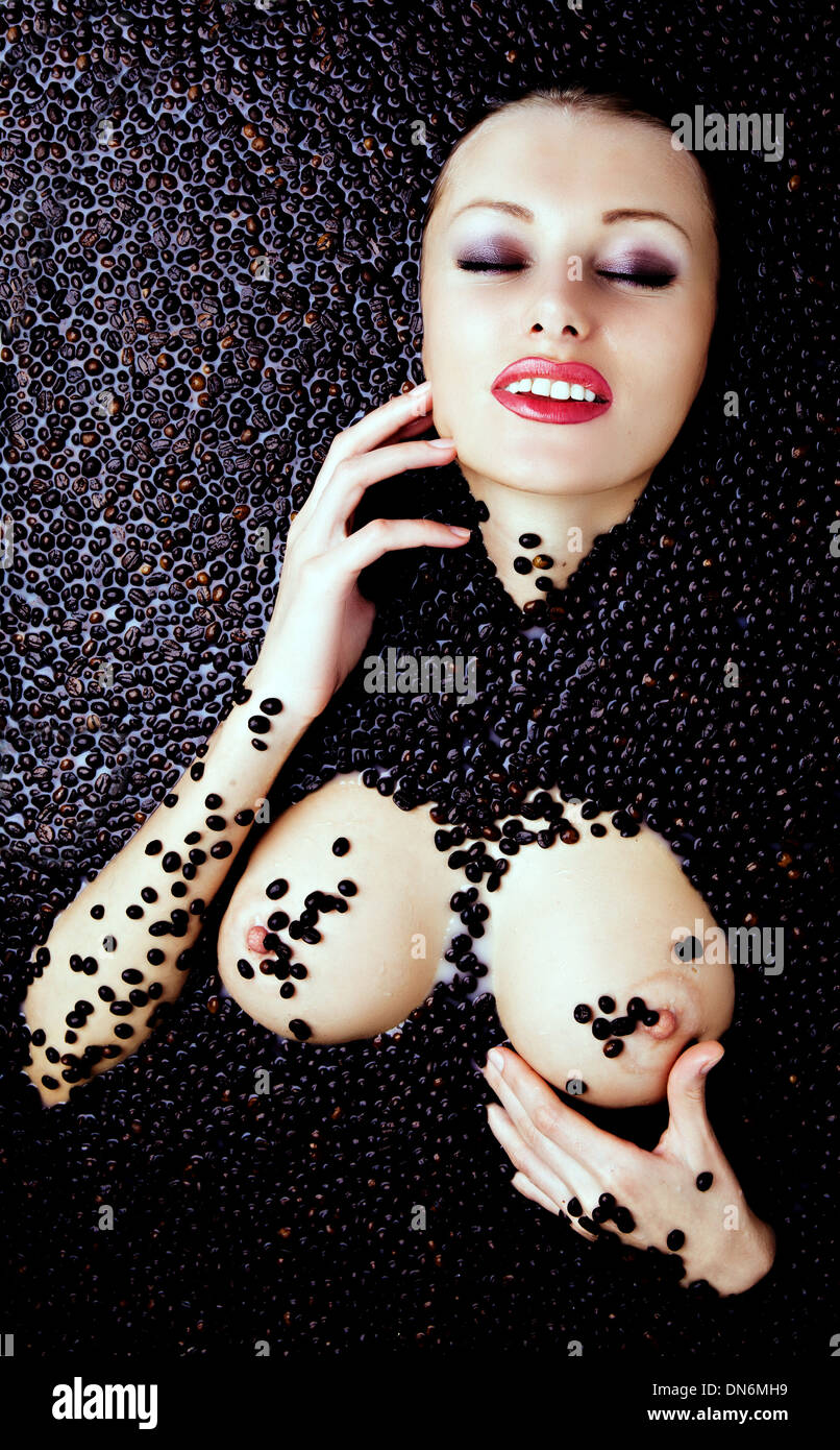 Mujer desnuda acostada en la bañera con granos de café Fotografía de stock  - Alamy