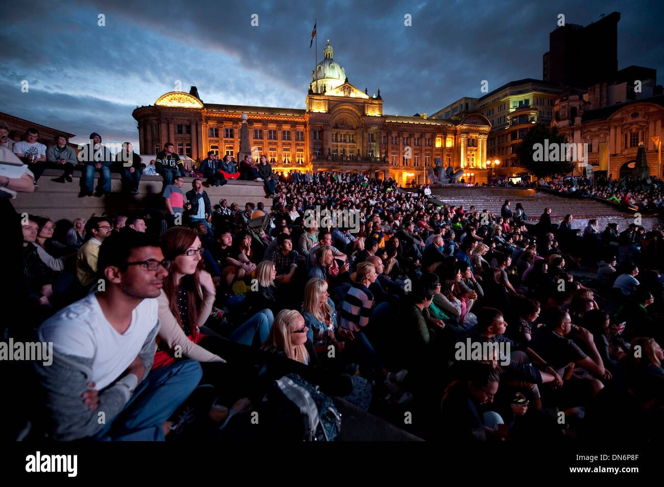 La ceremonia de apertura Olímpica 2012 es visto por cientos en una gran pantalla de televisión en la Plaza Victoria, Birmingham, Inglaterra. Foto de stock