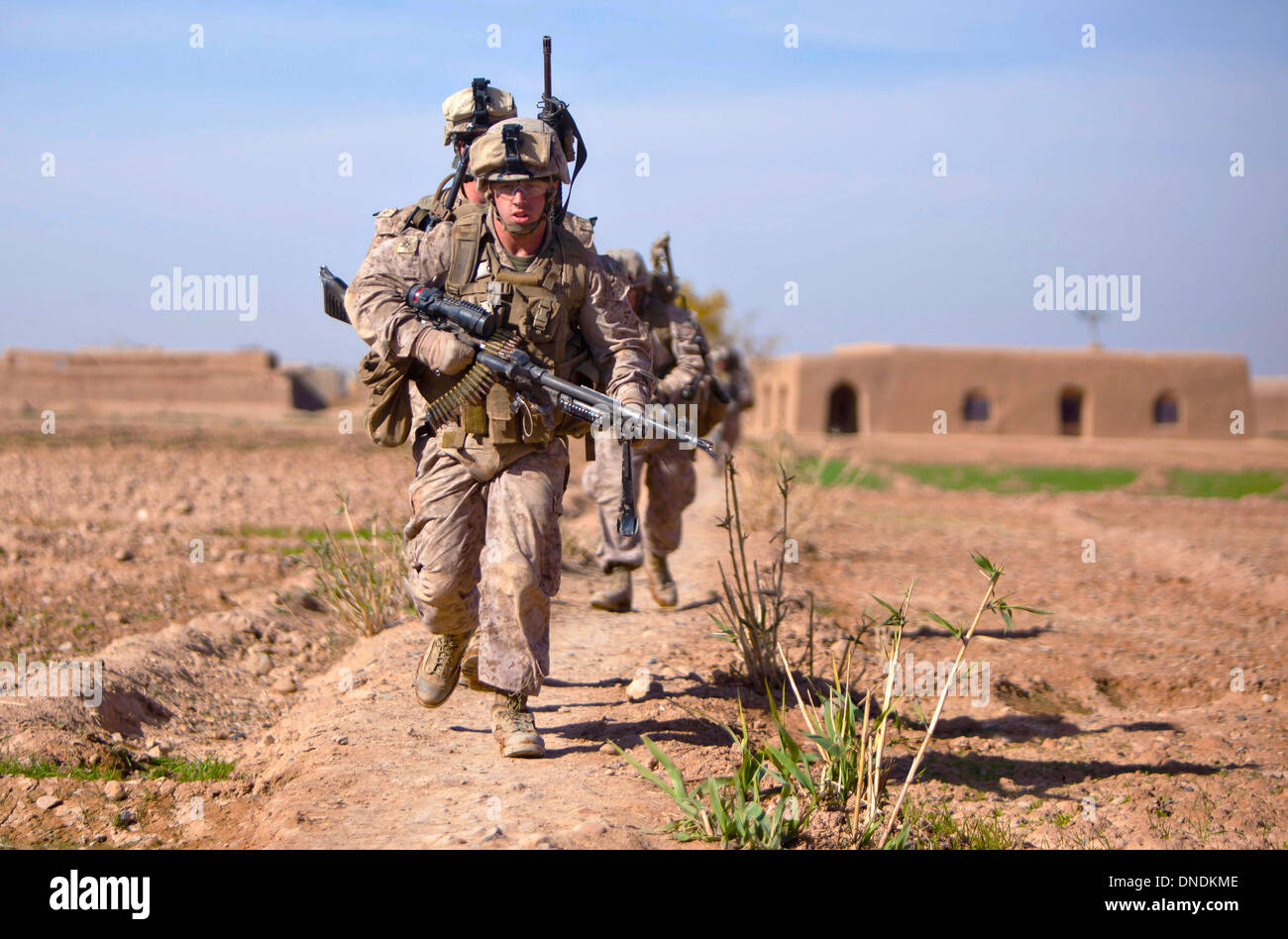 US Marine Corps Lance Cpl. Brian Barker, encabeza un grupo de infantes de marina para cubrir cerca de Bari Gul Bazar durante un prolongado tiroteo con los insurgentes, el 4 de diciembre de 2013 en el distrito de Nad Ali, provincia de Helmand, Afganistán. Foto de stock