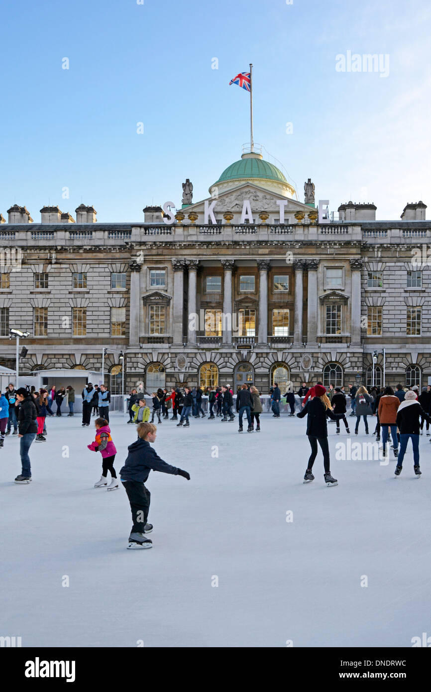 Adultos y niños patinadores de hielo con fondo histórico Somerset House Edificio y patio en invierno temporal pista de patinaje sobre hielo Strand Londres Inglaterra Reino Unido Foto de stock