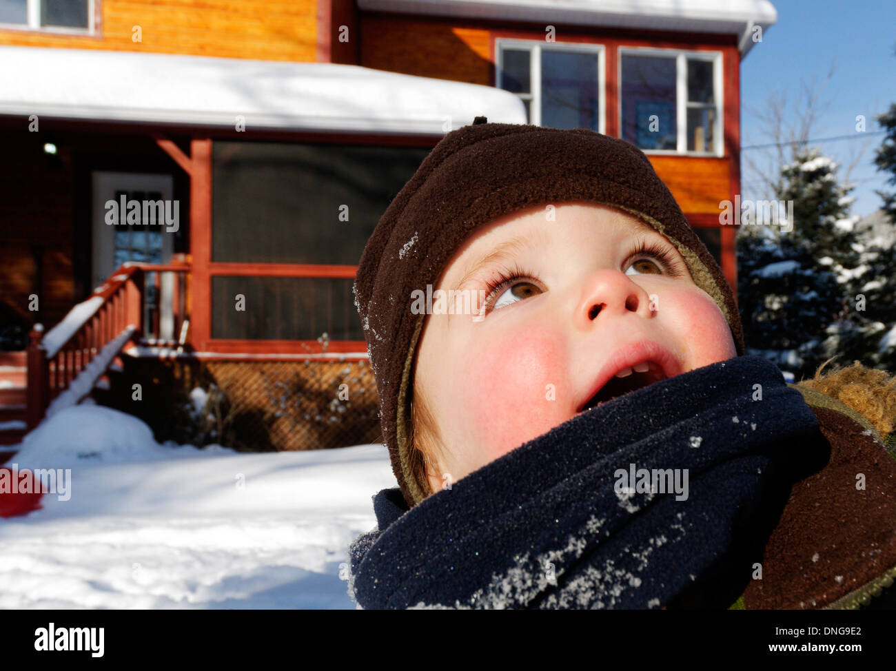 Un bebé fuera en invierno mirando hacia arriba Foto de stock