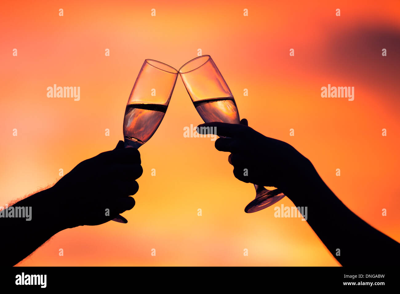 Silueta de pareja beber champán al atardecer Foto de stock