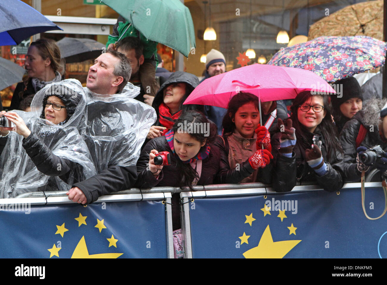 Londres, Reino Unido, 1 de enero de 2014,muchedumbre espera en la lluvia para el Londres del desfile del Día de Año Nuevo de 2014. Crédito: Keith Larby/Alamy Live News Foto de stock