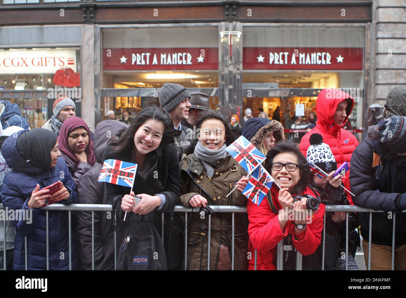 Londres, Reino Unido, 1 de enero de 2014,multitudes sonrisa a pesar de la lluvia, esperando el Londres del desfile del Día de Año Nuevo de 2014. Crédito: Keith Larby/Alamy Live News Foto de stock