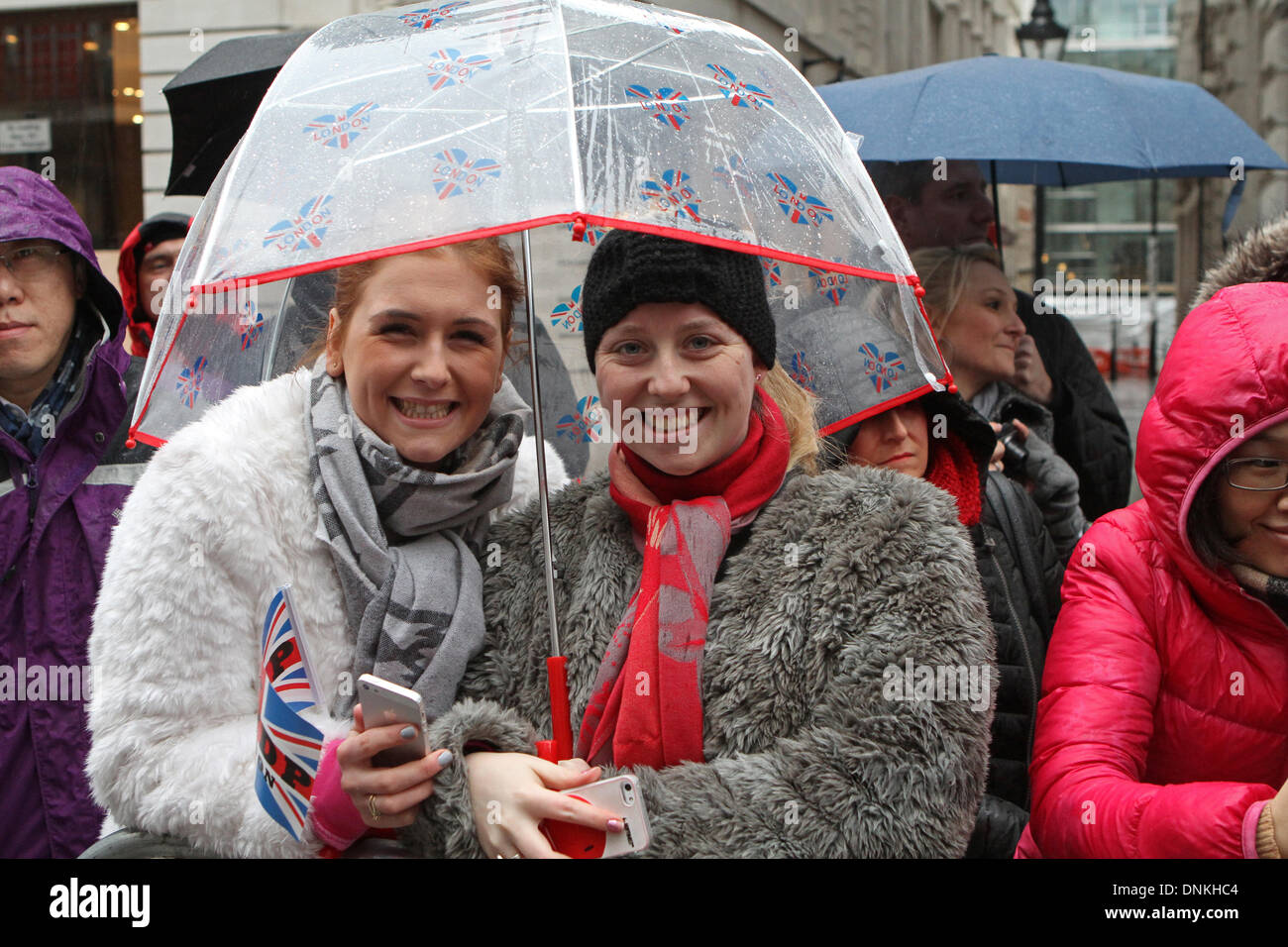 Londres, Reino Unido, 1 de enero de 2014,refugiarse bajo un paraguas en Londres el día de Año Nuevo de 2014 Desfile de crédito: Keith Larby/Alamy Live News Foto de stock