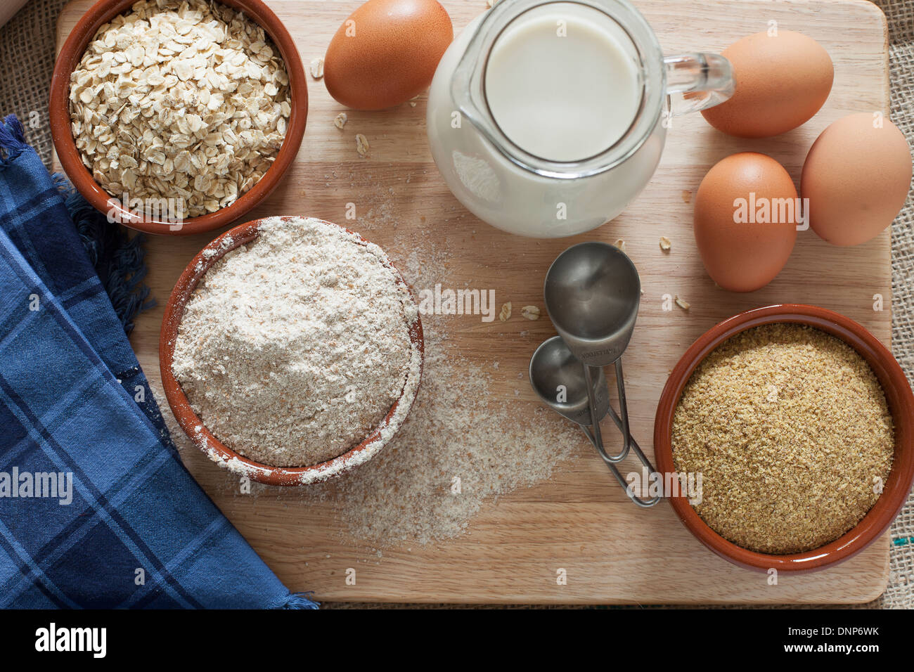 Ingredientes para grano entero pan sano, la harina de trigo integral, copos de avena y germen de trigo con leche y huevos. Foto de stock