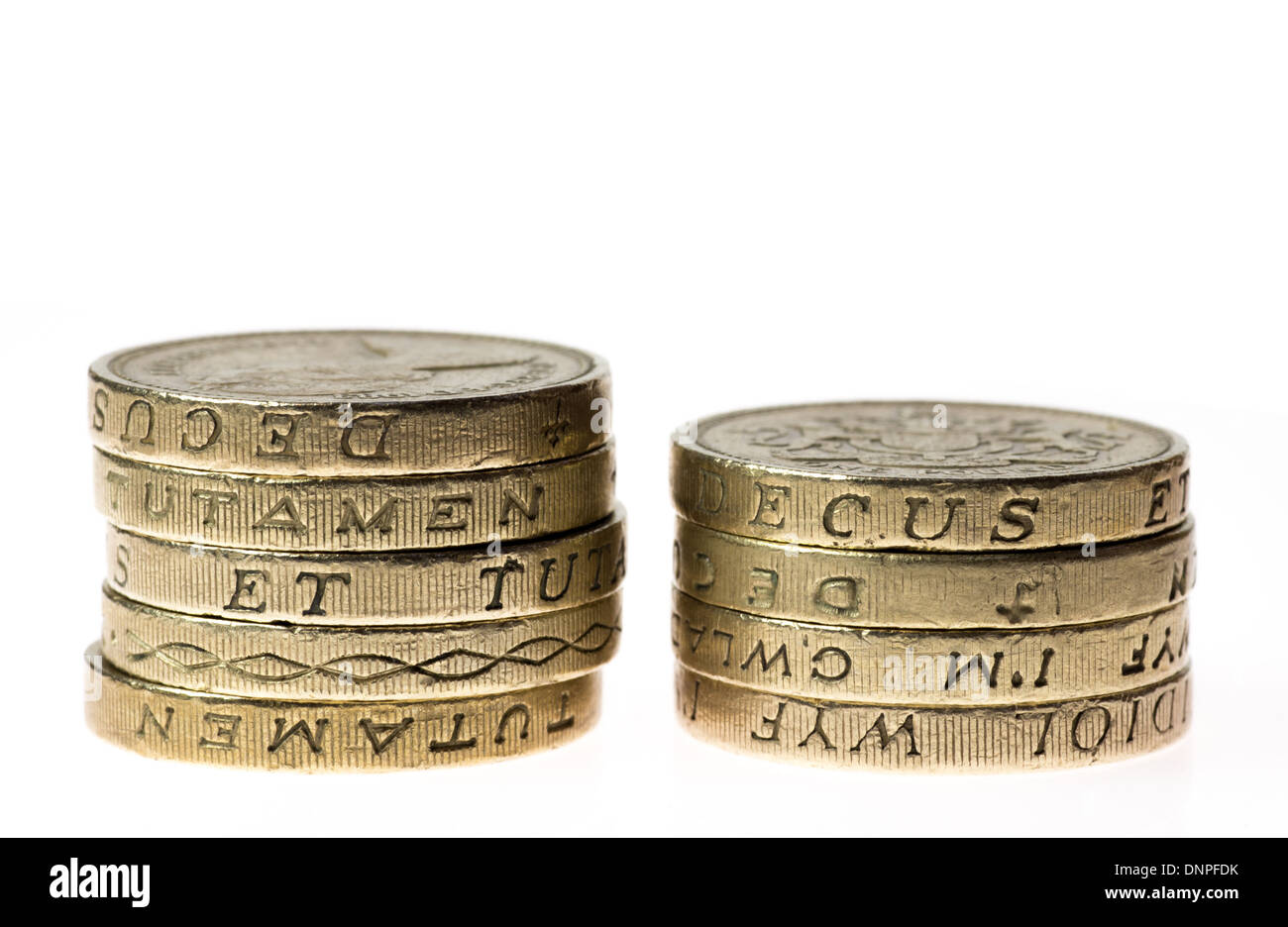 Dos montones desiguales de monedas de una libra británica Foto de stock