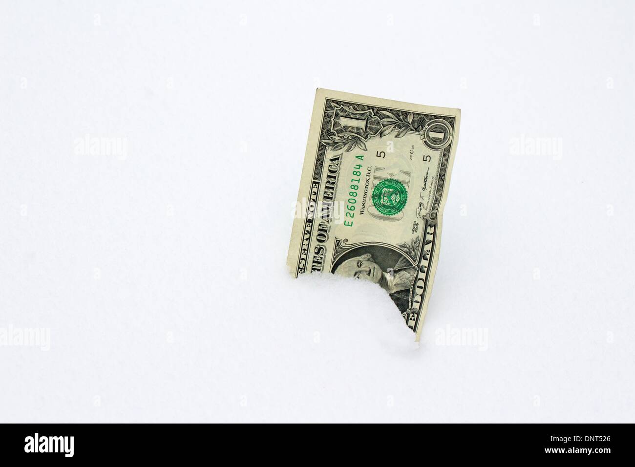 Oak Park, Illinois, EE.UU.. 5 de enero de 2014. Un EE.UU. $1.00 Bill incrustado en la nieve. Este invierno en nevado y gélido es una posible presión sobre los presupuestos municipales para la remoción de nieve y calefacción doméstica en los presupuestos. Crédito: Todd Bannor/Alamy Live News Foto de stock