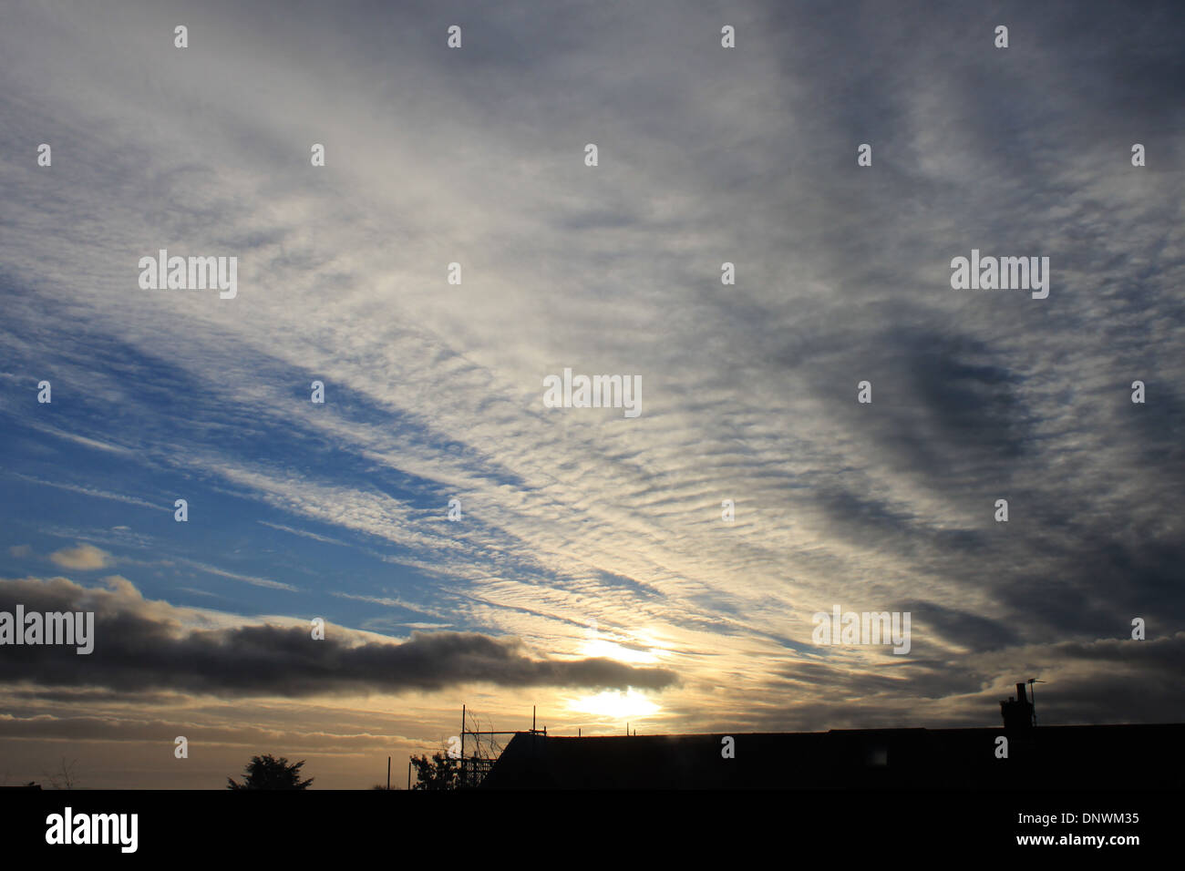 Interesante cúmulos, cirros y cirrocúmulos formaciones nubosas al amanecer en una mañana de invierno en Hampshire, Reino Unido Foto de stock