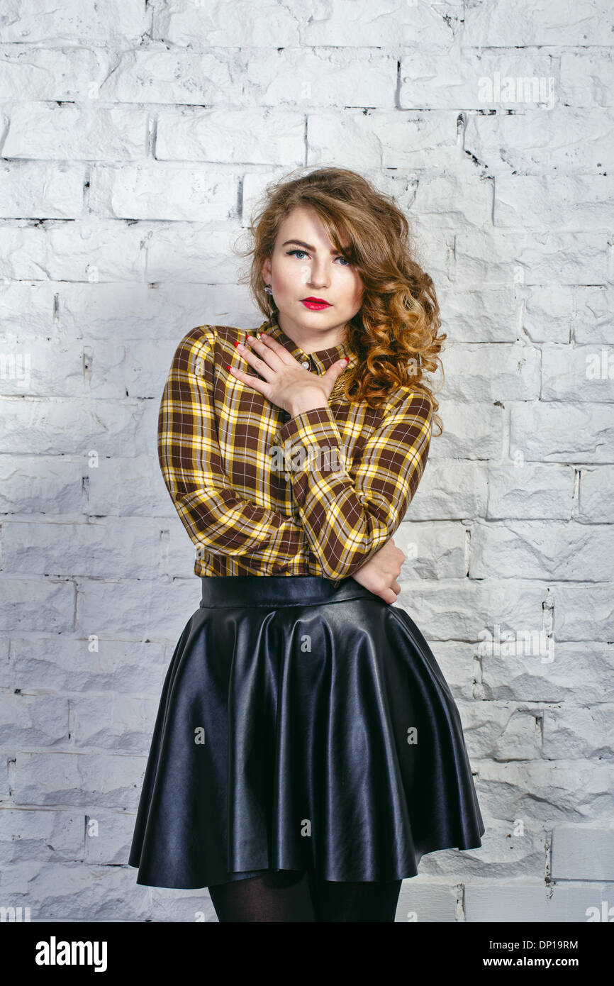 Muchacha atractiva en el Plaid camisa y falda de cuero Foto de stock