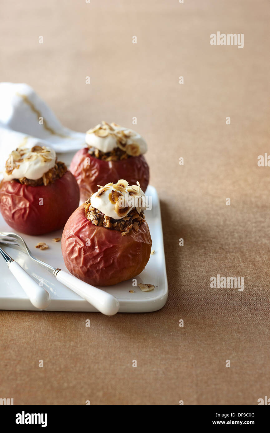 Las manzanas rojas horneadas rellenas con avena, yogur, granola y Foto de Estudio Foto de stock