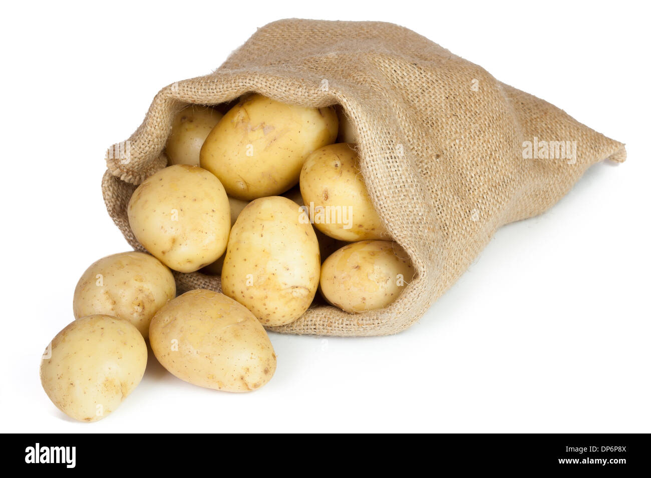 Patatas crudas en bolsa de arpillera aislado sobre fondo blanco. Foto de stock