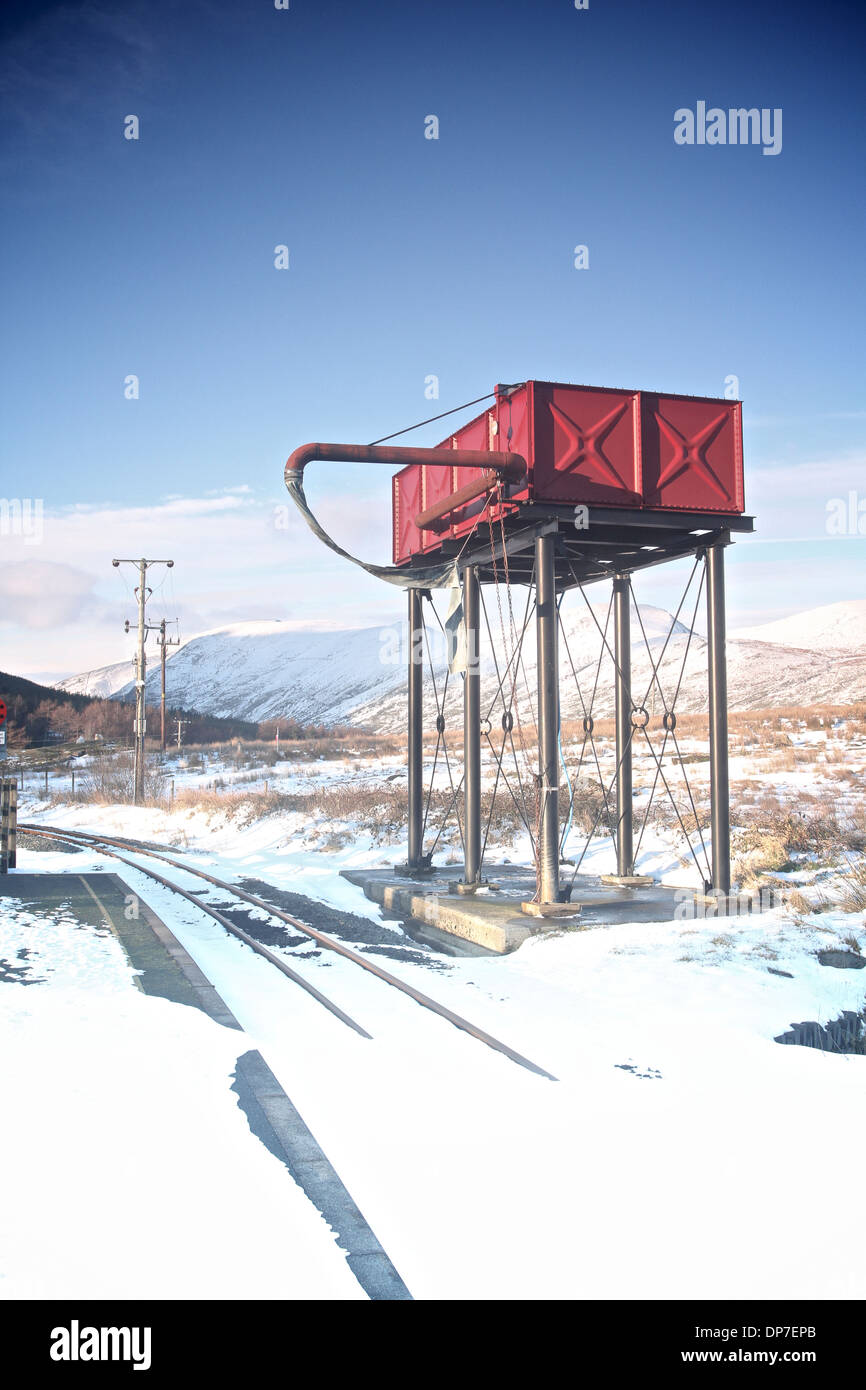 Torre del depósito de agua para rellenar los trenes a vapor en el ferrocarril de vía angosta en Rhyd DDU, el parque nacional de Snowdonia, Gales en invierno Foto de stock