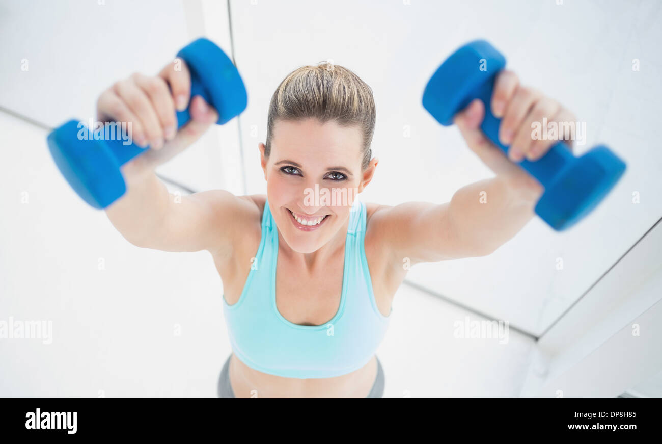 Mujer joven rubia centrada en ropa para hacer ejercicio El ejercicio solo  con pesas en el gimnasio Fotografía de stock - Alamy