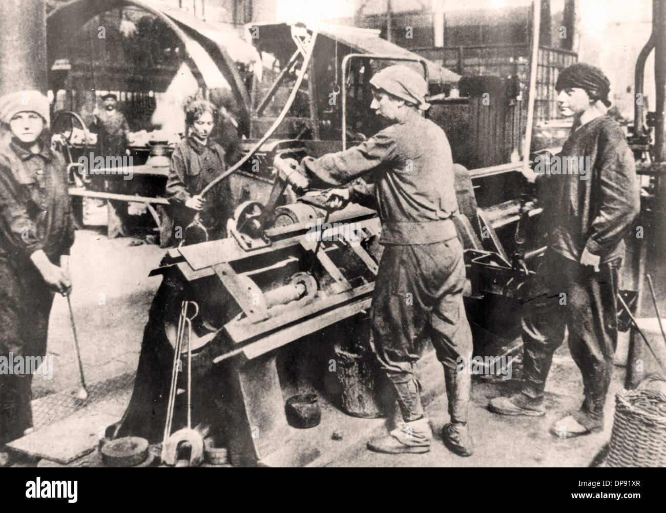 Las mujeres trabajan en una fábrica de municiones en una prensa de dibujo de 125 toneladas, lugar y fecha desconocidos. Archivo fotográfico für Zeitgeschichte Foto de stock