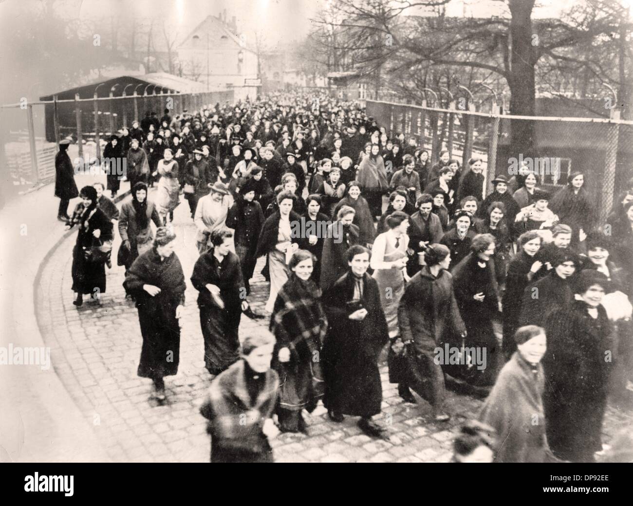 Las mujeres abandonan una fábrica alemana de armas y municiones después de que su turno haya terminado, lugar y fecha desconocidos. Archivo fotográfico für Zeitgeschichte Foto de stock
