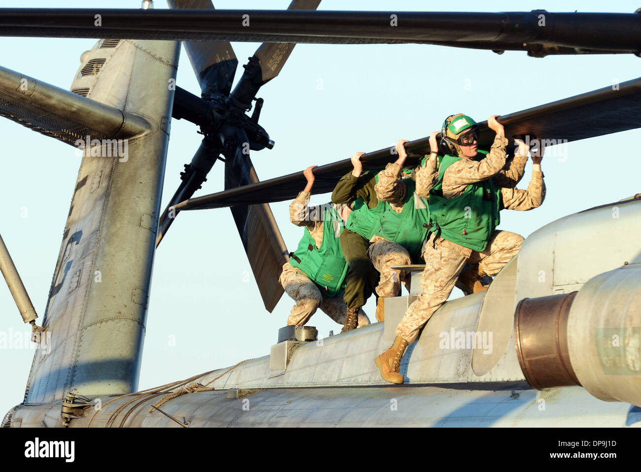 Marines alinear las palas del rotor de un tipo CH-53E Super Stallion helicóptero para estiba Foto de stock