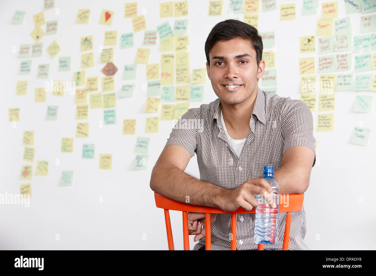 Retrato de joven con notas adhesivas en segundo plano. Foto de stock