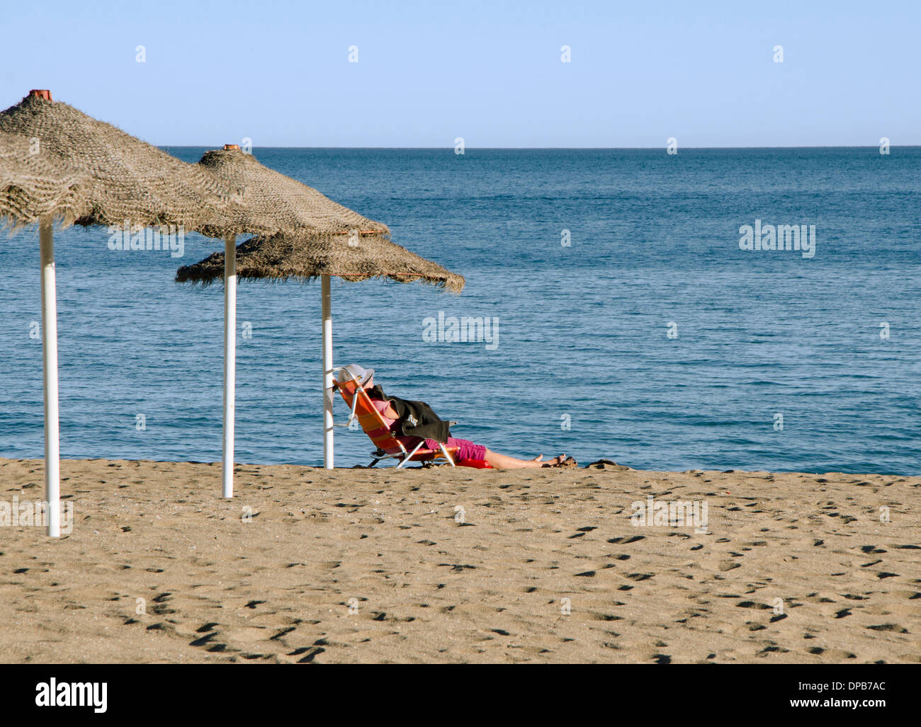 Mujer en la playa del mar mediterráneo en invierno para tomar el sol. Costa del Sol, España Foto de stock