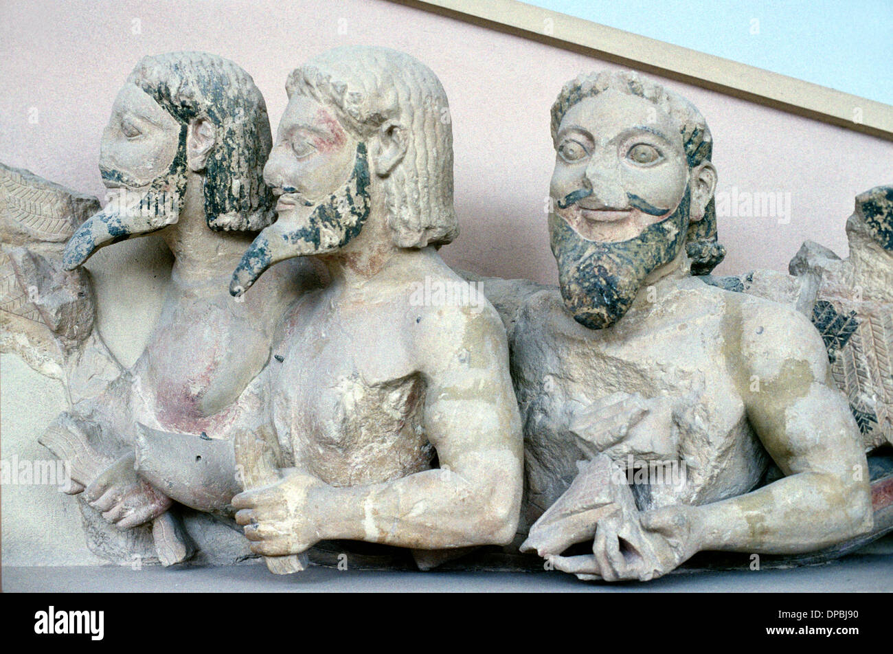 Tres cuerpo monstruo barbudo en el frontón de c6th BC templo griego en piedra porosa Foto de stock