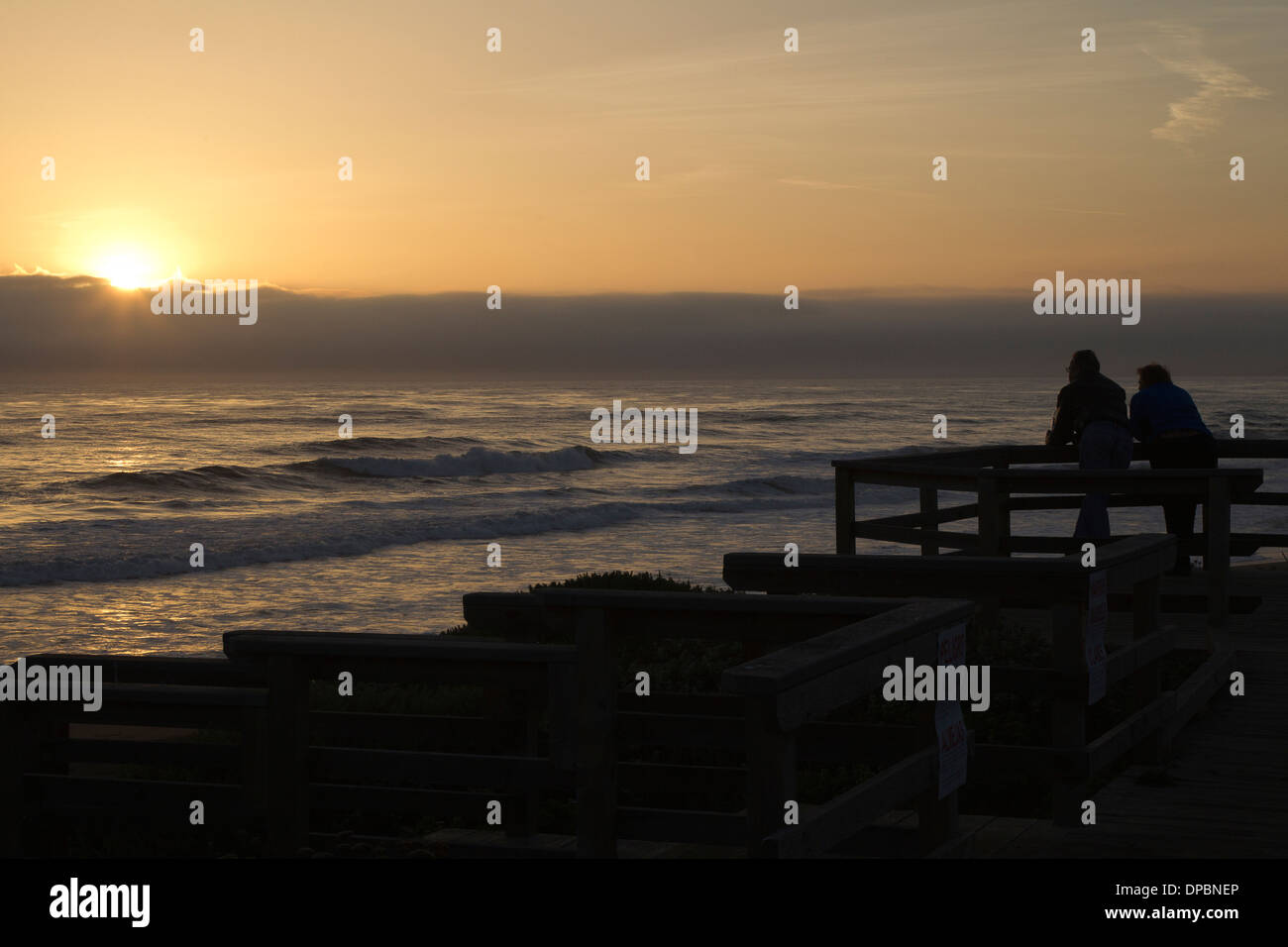 Gente viendo la puesta de sol sobre el Océano Pacífico Foto de stock