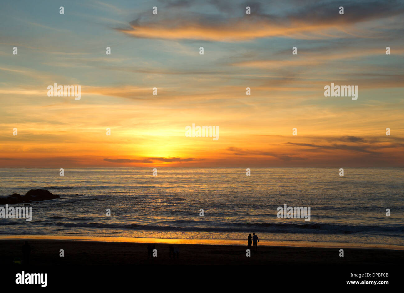 Gente viendo la puesta de sol sobre el Océano Pacífico Foto de stock