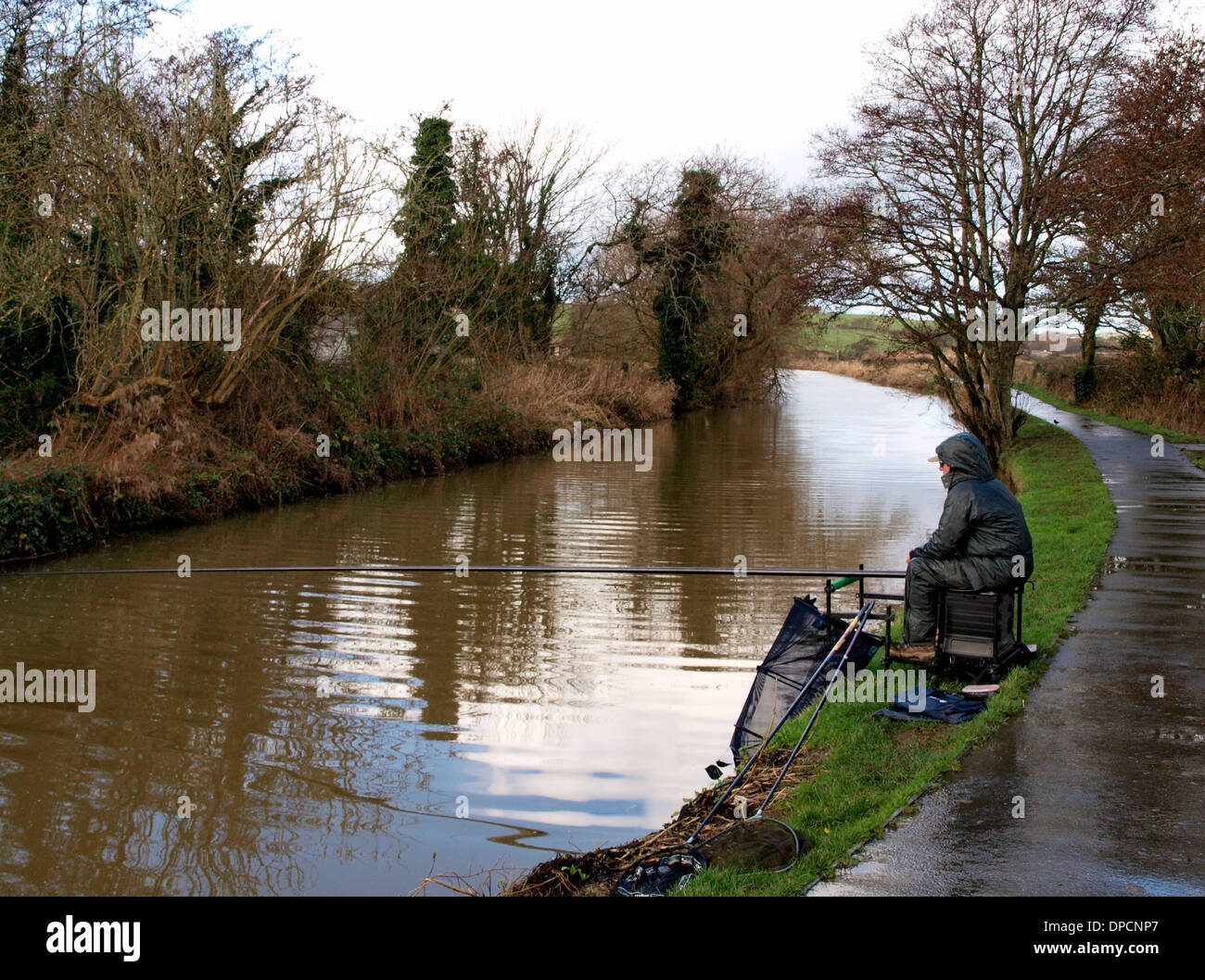Hombre que pesca en el canal de Bude en un día de invierno húmedo, Cornualles, en el REINO UNIDO Foto de stock