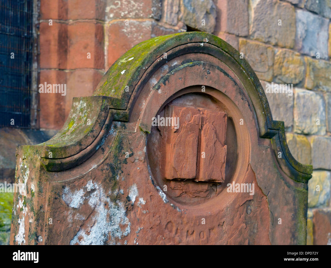 Gravemente erosionadas lápidas con diseño de libro. Iglesia de San Miguel. Torpenhow, Cumbria, Inglaterra, Reino Unido, Europa. Foto de stock