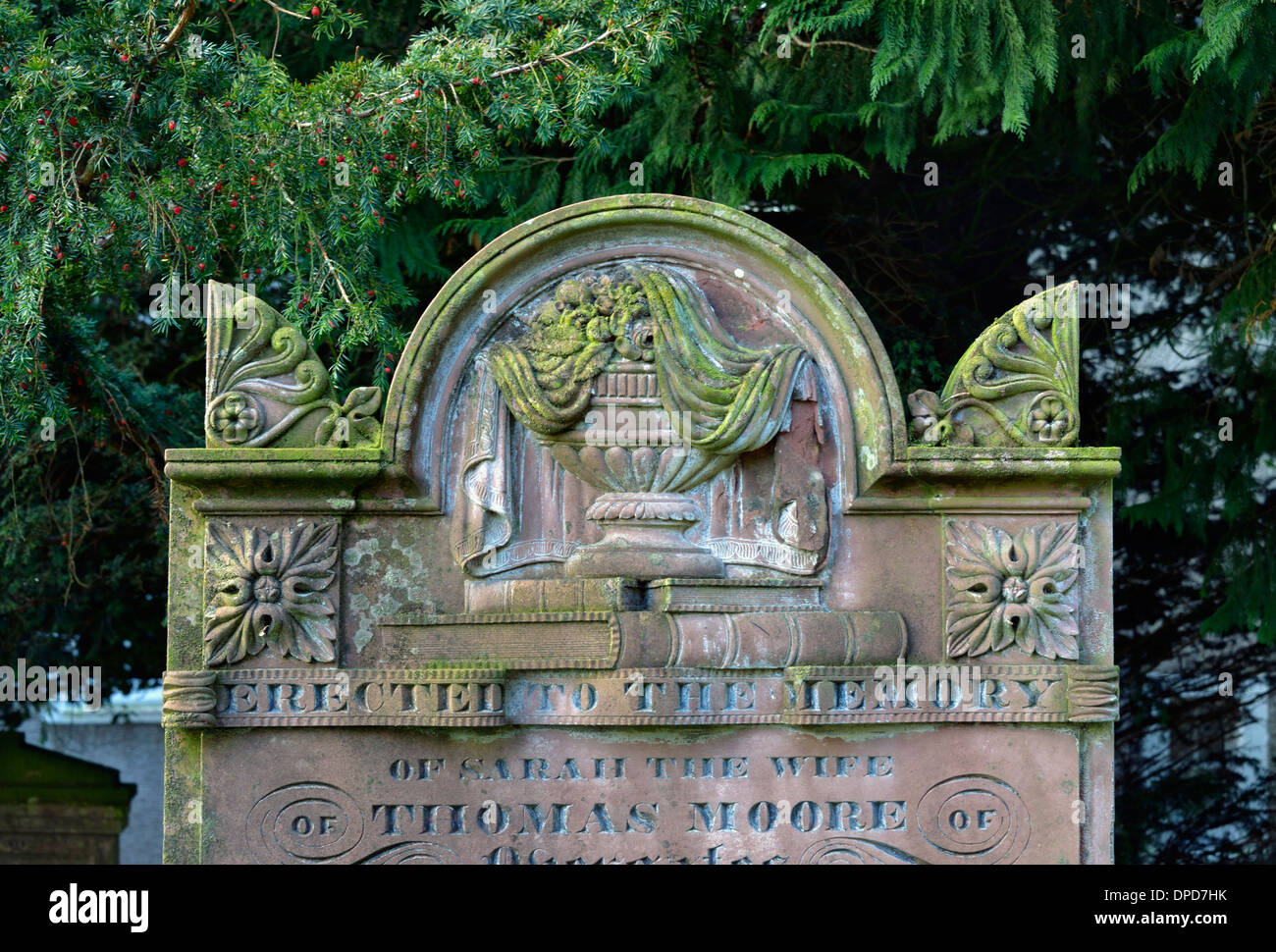 Lápida con sábanas urn y diseño de libros. Iglesia de San Miguel. Torpenhow, Cumbria, Inglaterra, Reino Unido, Europa. Foto de stock