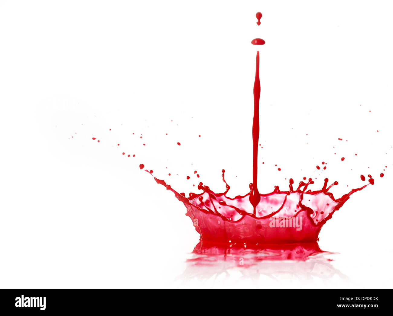 Pintura roja cayendo creando un chorrito Foto de stock